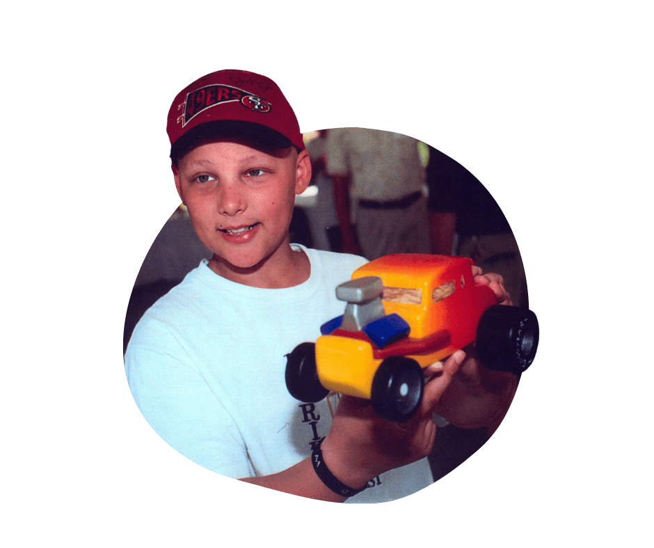 Boy with cancer holding toy car