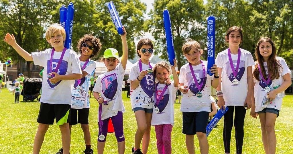 Smiling woman giving a piggyback ride to a laughing young girl.