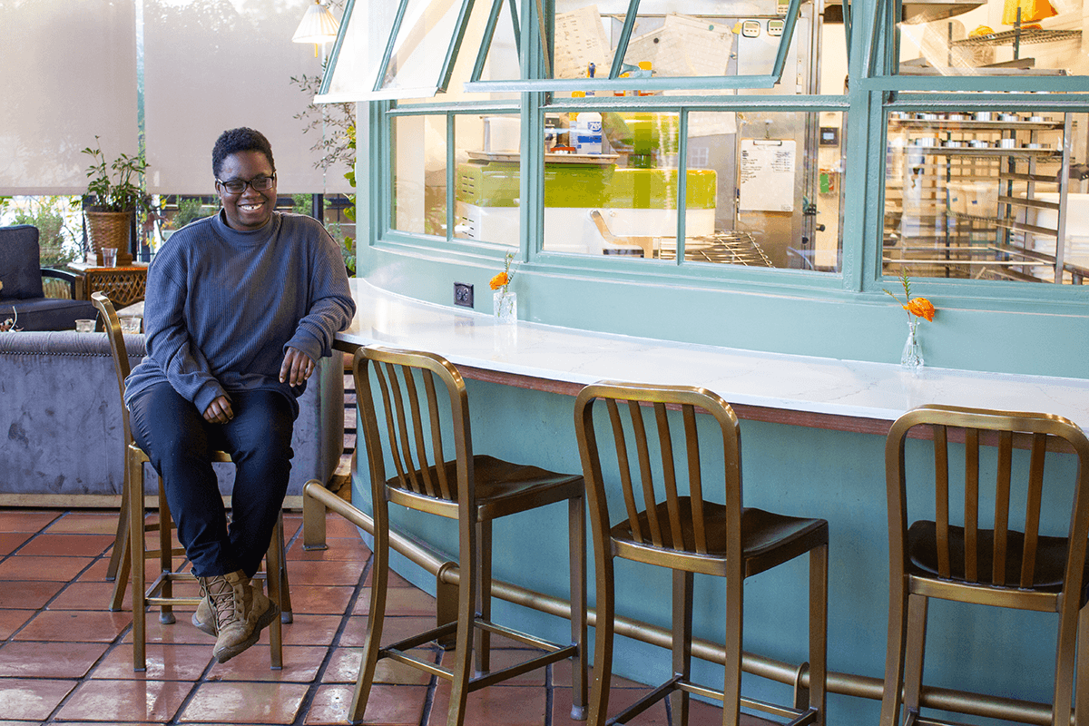 Smiling woman giving a piggyback ride to a laughing young girl.